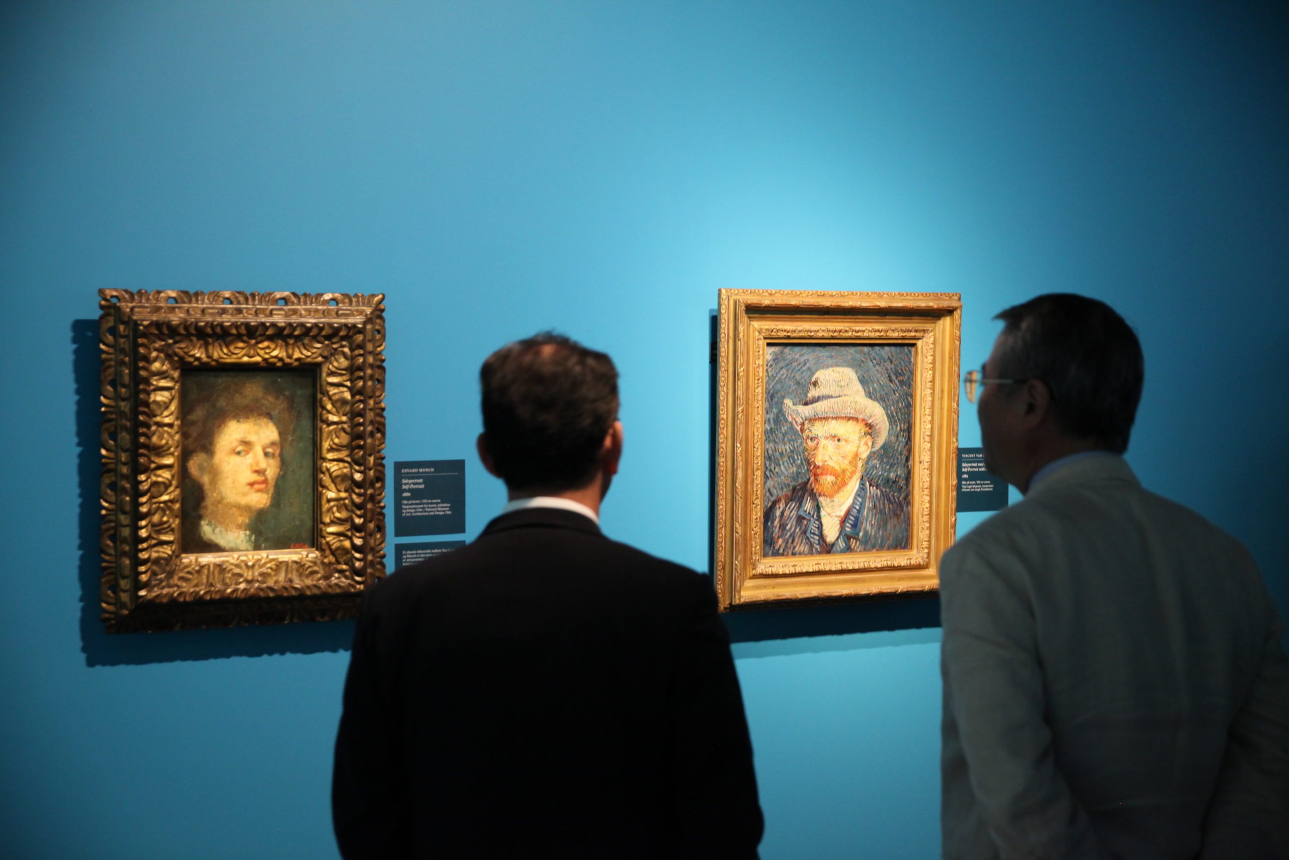 Visitors looking at Munch and van Gogh self portraits in Munchmuseet, 2015